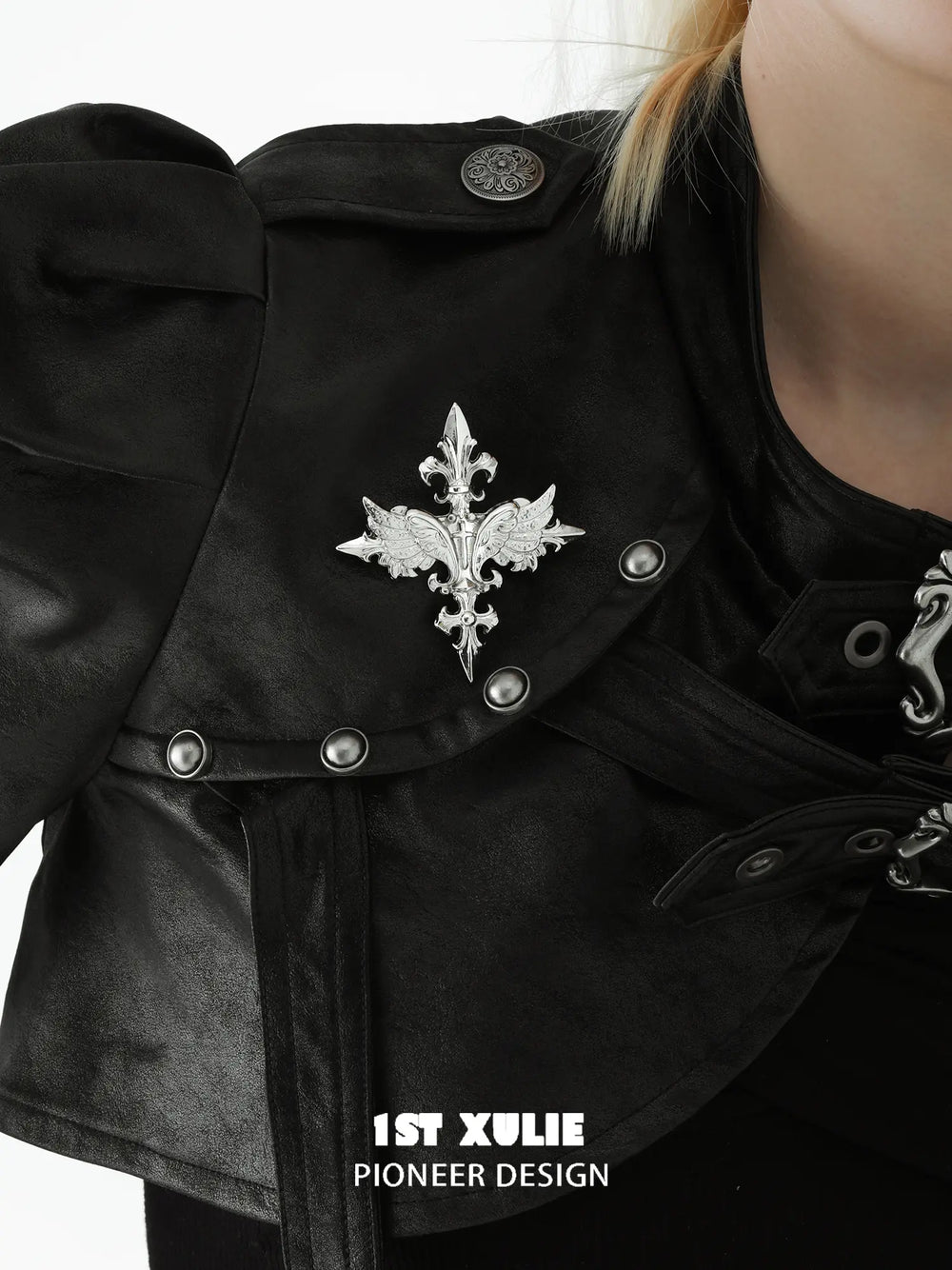 Silver-tone winged Fleur-de-Lis brooch styled on a jacket lapel.