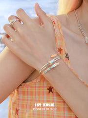 1ST XULIE Jewelry "Juicy Flight" Playful Paper Plane Cuff Bracelet in Platinum Plated Brass - Lifestyle Shot