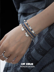 Blue beaded charm bracelet worn with coordinating jewelry