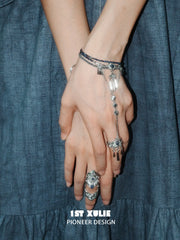 Blue stone bracelet-to-ring hand chain worn with coordinating jewelry