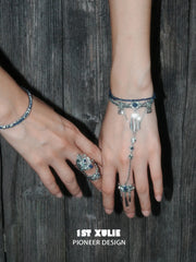Blue stone bracelet-to-ring hand chain worn with coordinating jewelry