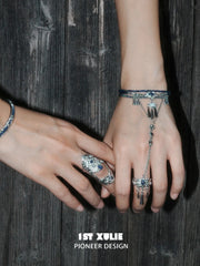 Blue stone bracelet-to-ring hand chain worn with coordinating jewelry