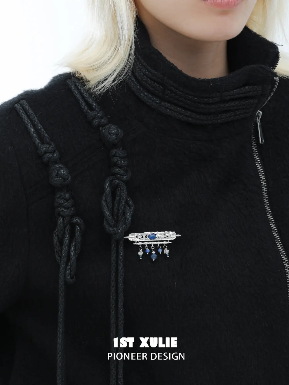 Blue stone brooch styled on a black high-neck top