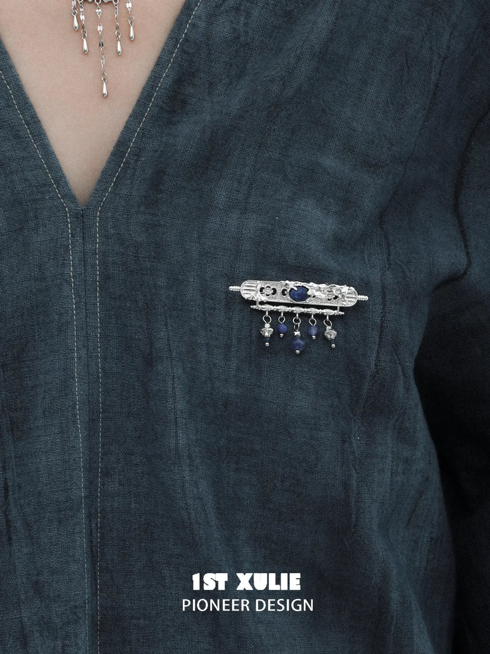Blue stone tassel brooch pinned to clothing