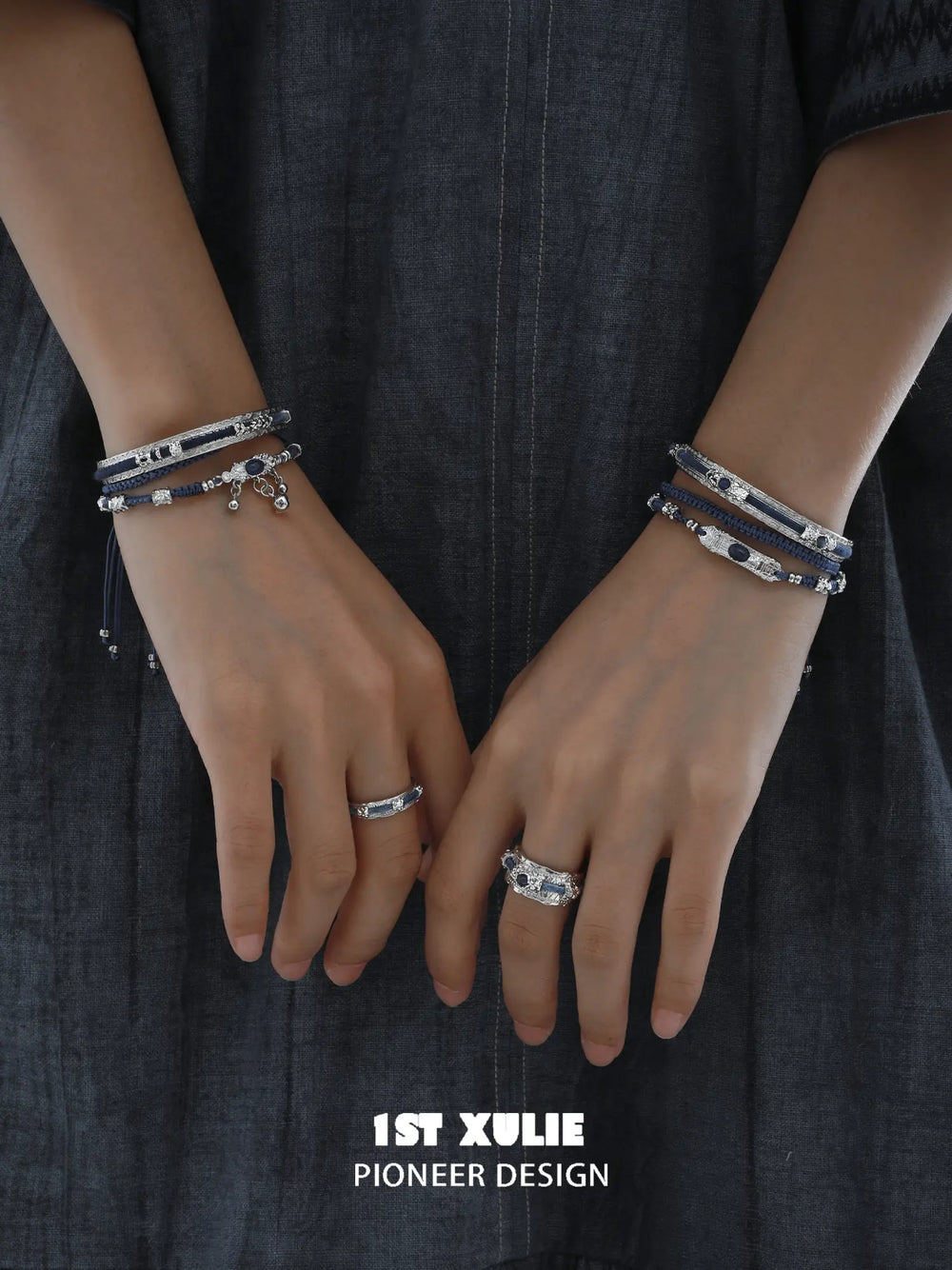 Narrow and wide blue woven rings worn with coordinating jewelry