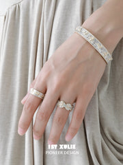Celestial bangle and white cord star bracelet worn with coordinating jewelry