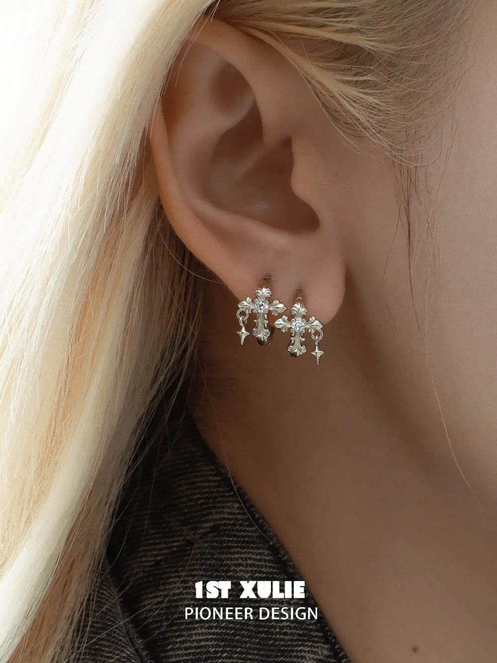 Gold-toned fleur-de-lis hoop and stud earrings worn on the ear