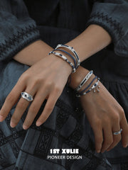 Wide blue woven ring styled with layered blue bracelets