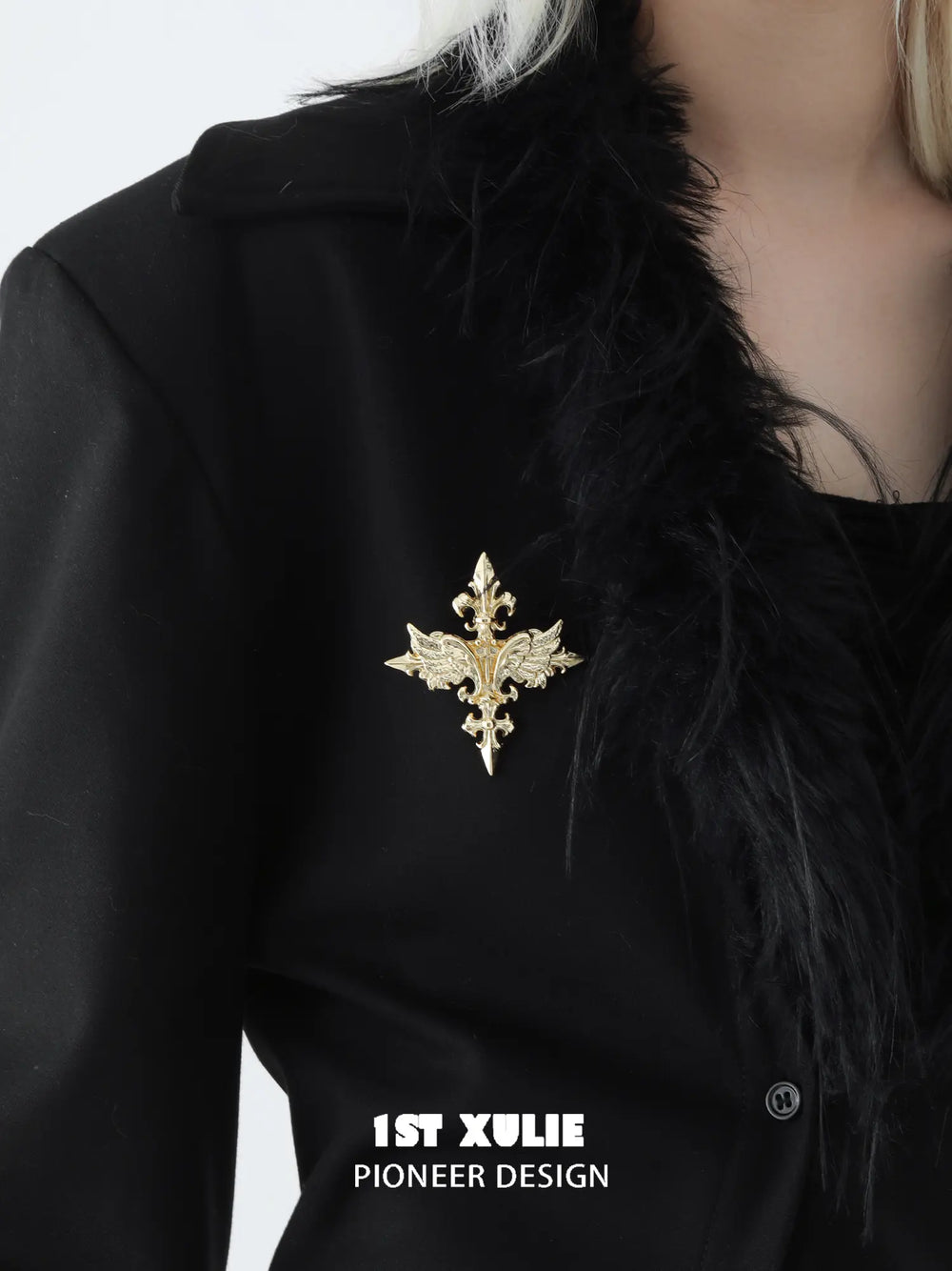 Gold-tone Fleur-de-Lis brooch styled on a black coat.