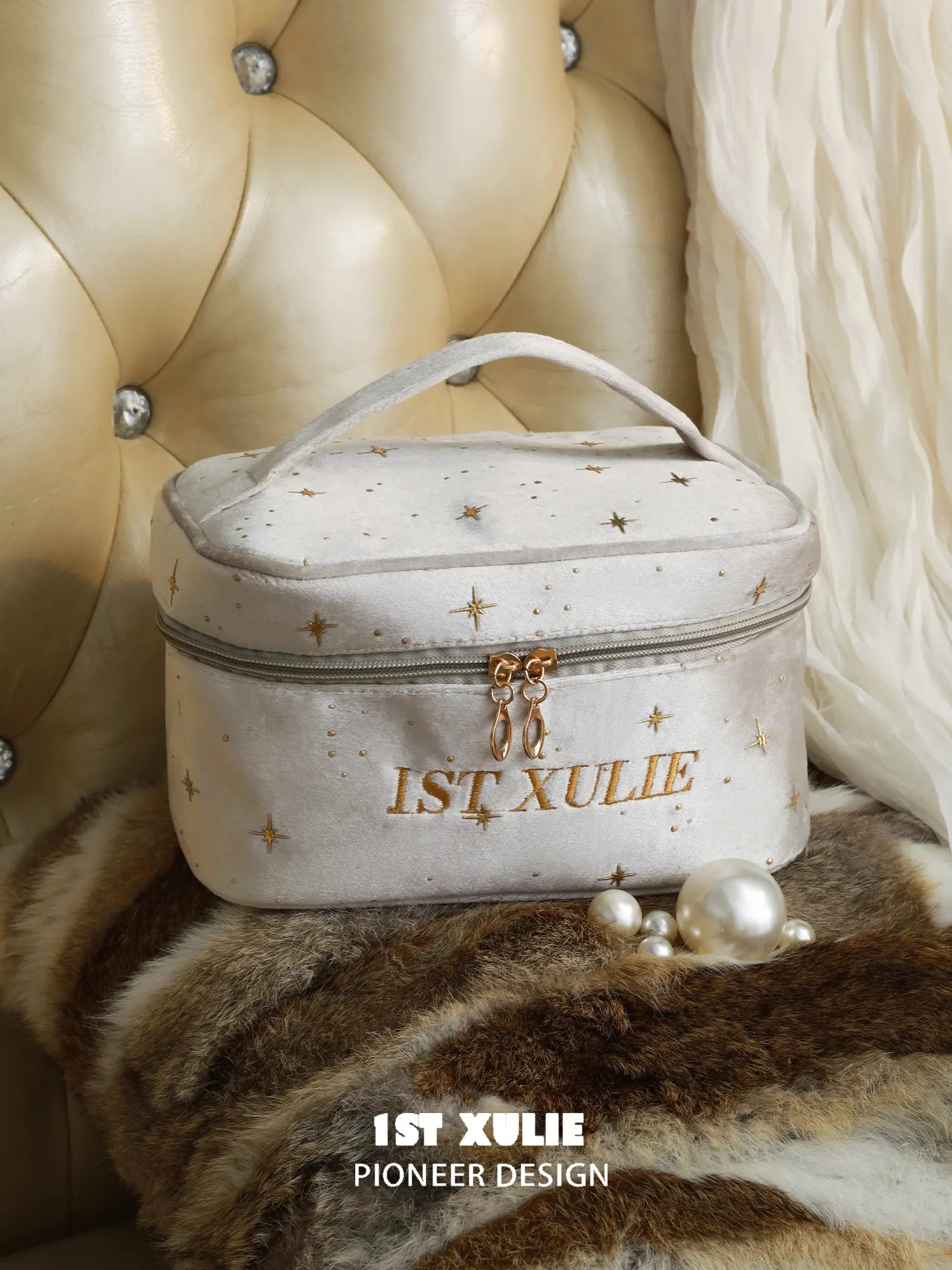 Light gray 1ST XULIE velvet makeup bag with gold star details and double zipper.