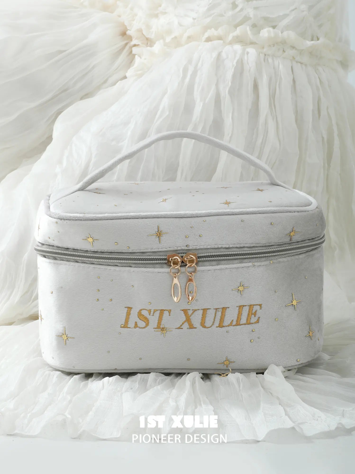 Close-up of the light gray velvet makeup bag, carry handle and 1ST XULIE branding.
