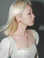 1ST XULIE "Bastet" Iris Blossom Huggie Hoop Earrings in Rhodium Plated - Lifestyle Shot