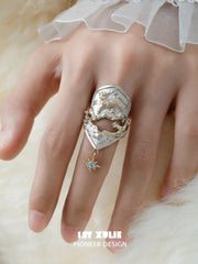 Celestial armor ring with a hanging star worn with coordinating jewelry