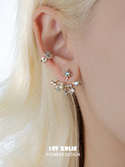 Full celestial earring worn below a pale blue star stud