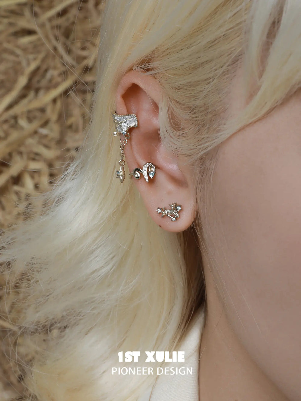 Miniature gold-toned ram stud earrings worn on the lobe