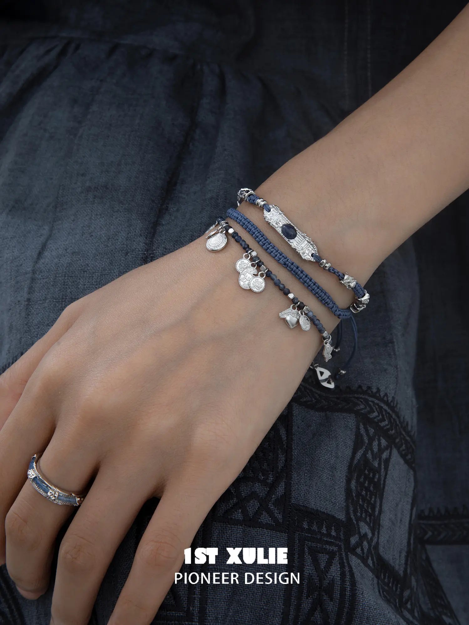 Blue beaded charm bracelet worn with coordinating jewelry