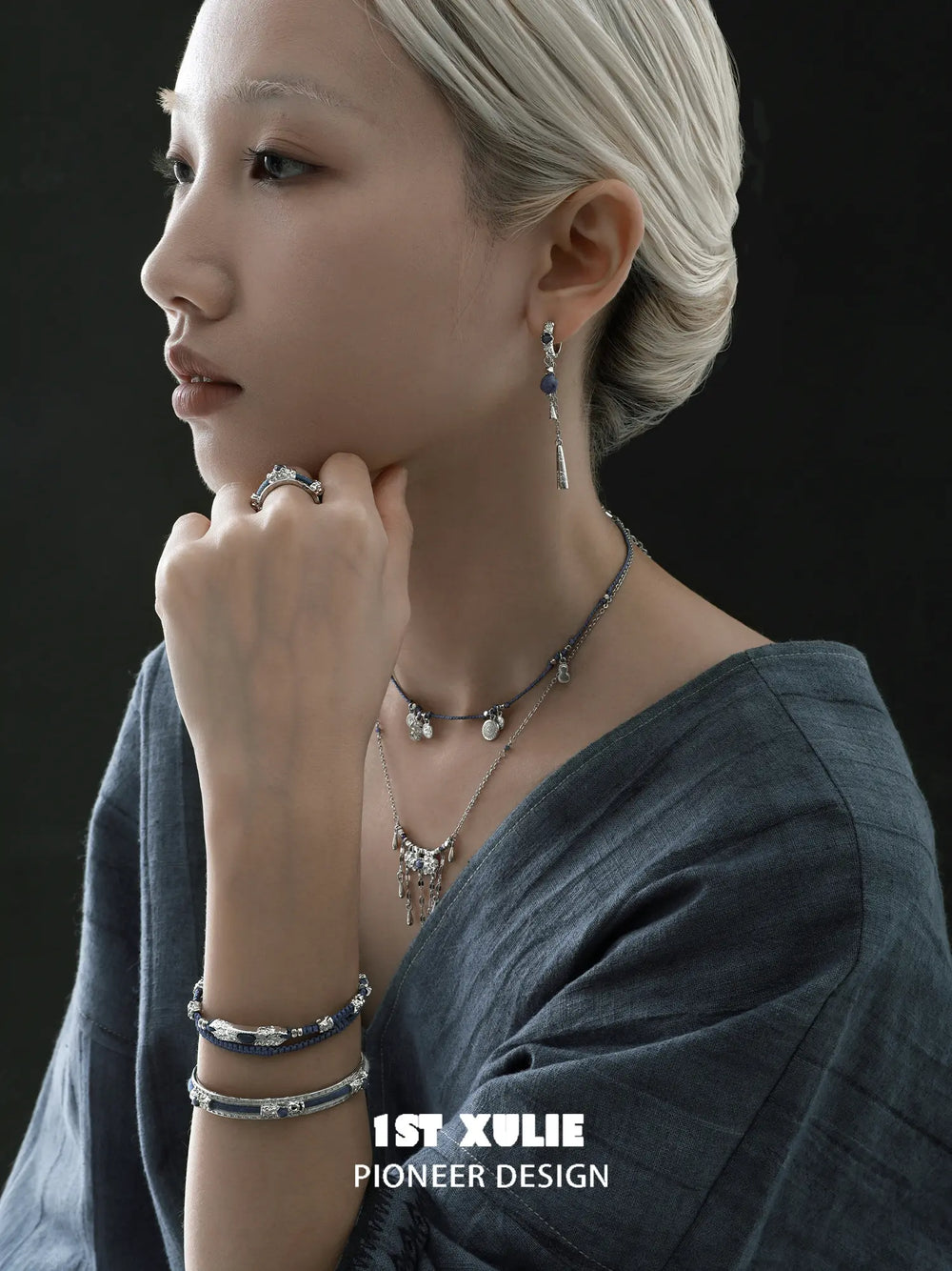 Blue braided charm bracelets worn with coordinating jewelry