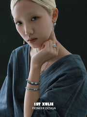 Blue braided charm bracelets worn with coordinating jewelry