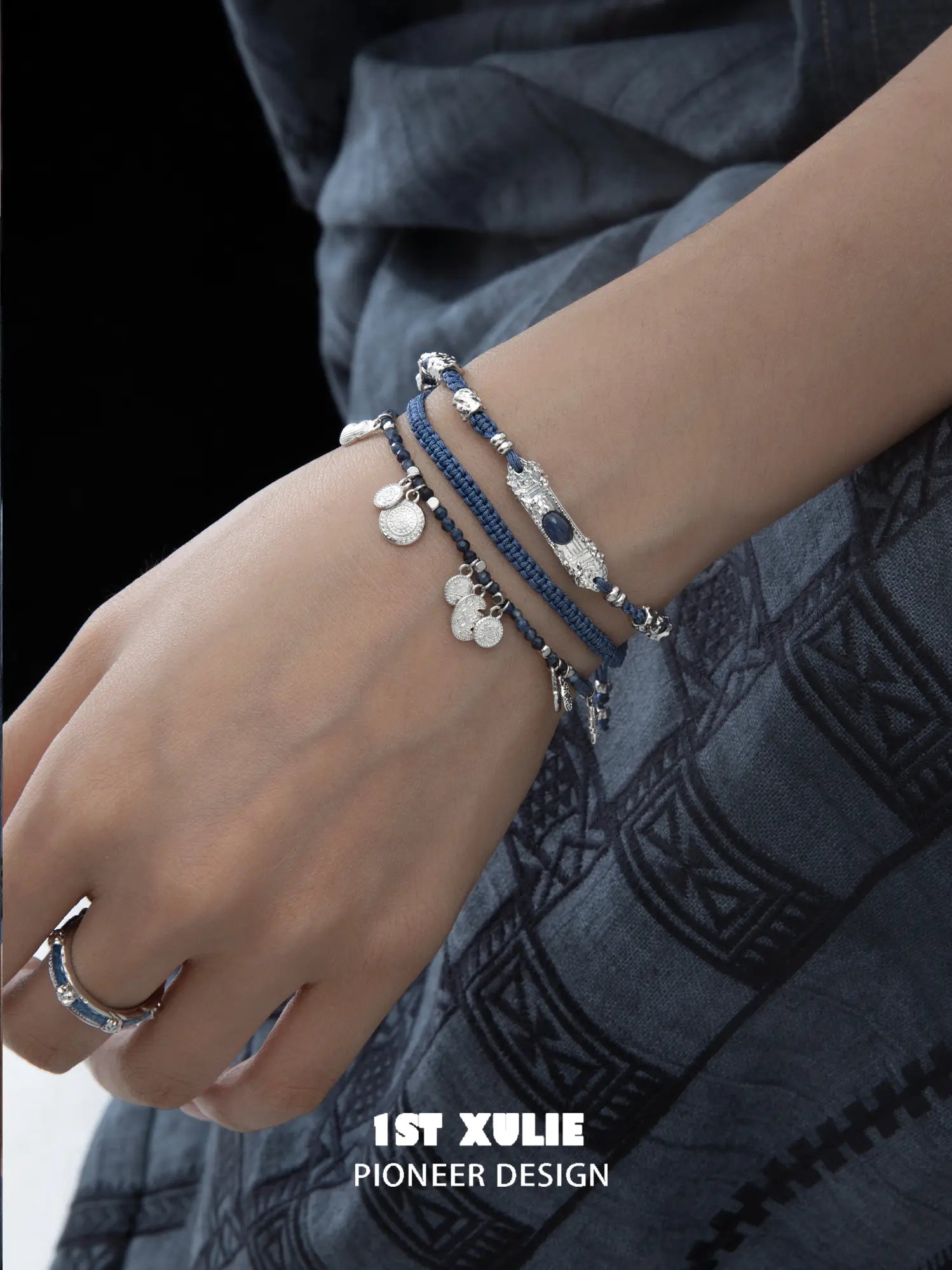 Blue braided charm bracelets worn with coordinating jewelry