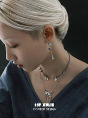 Blue cord and tassel layering necklaces layered at the neckline