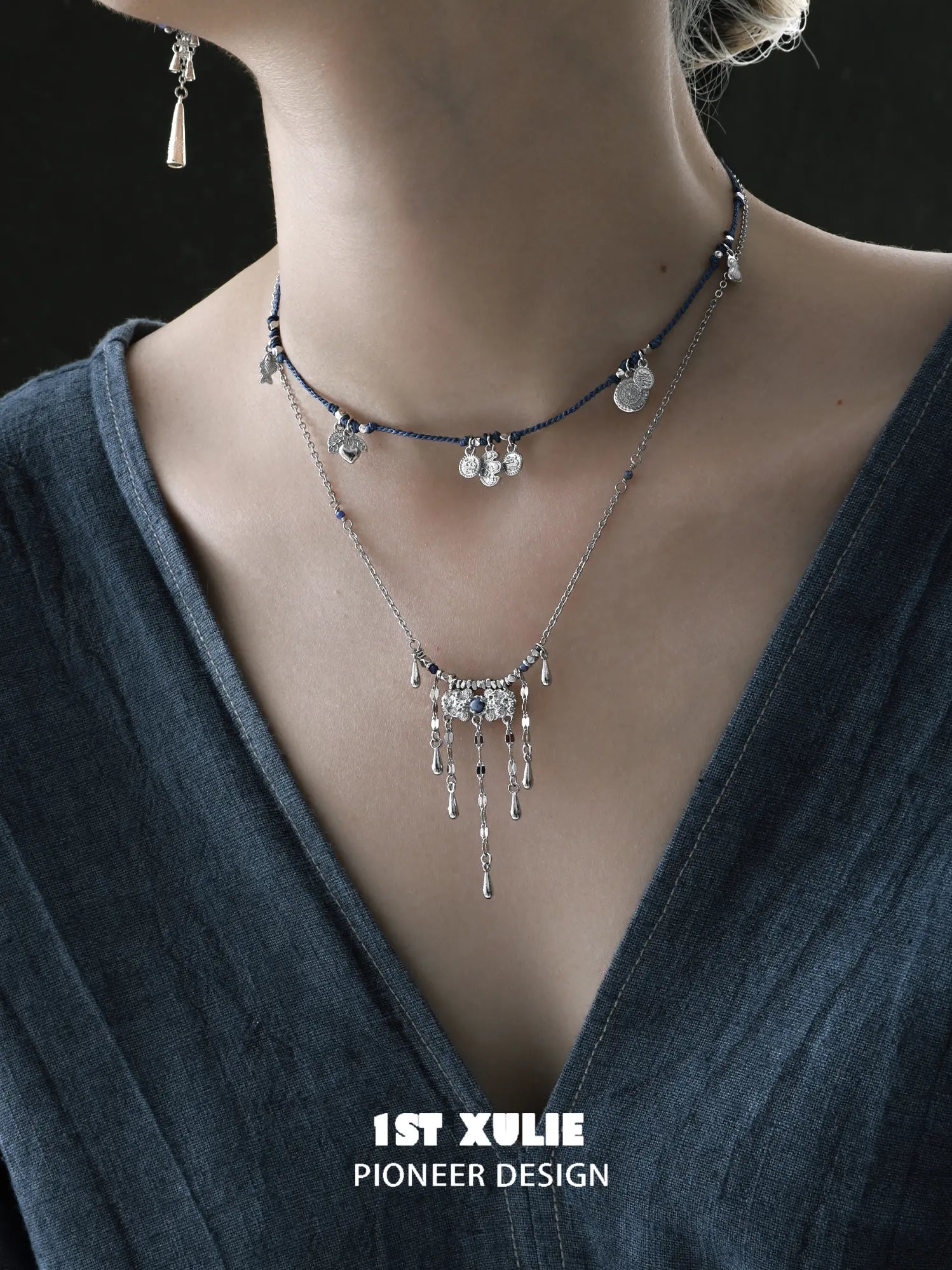 Close view of the blue cord necklace layered above the tassel necklace