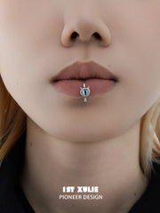 Front close-up showing the eye motif and small drop beneath the lip cuff
