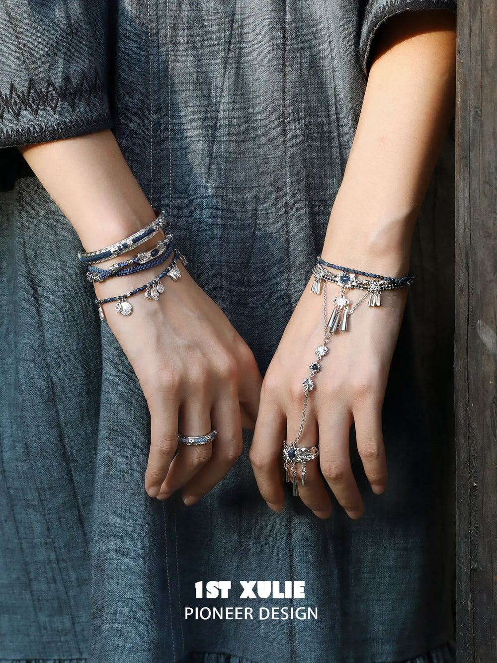 Blue stone bracelet-to-ring hand chain worn with coordinating jewelry