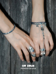 Blue hand chain worn beside a coordinating articulated ring