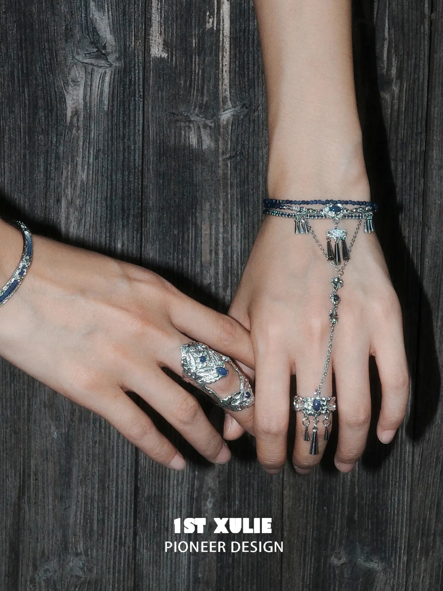 Blue stone bracelet-to-ring hand chain worn with coordinating jewelry