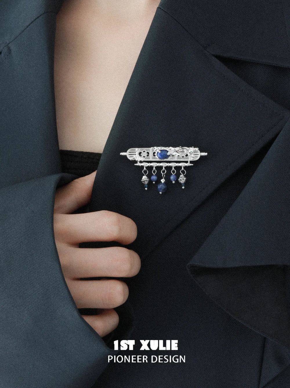 Blue stone tassel brooch pinned to a dark jacket lapel