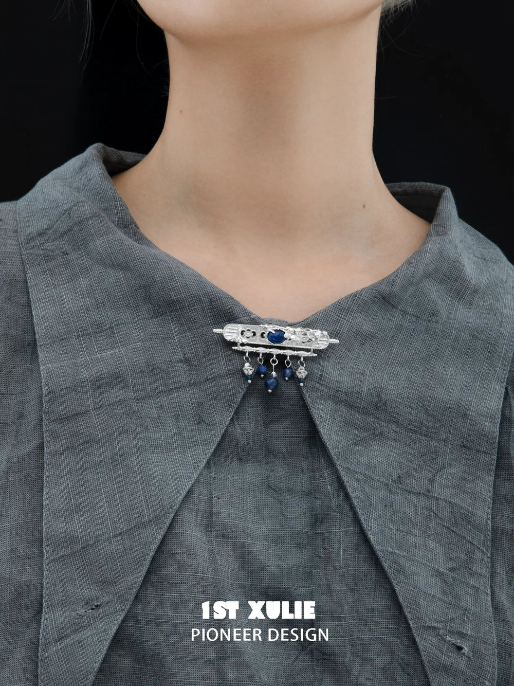 Blue stone tassel brooch pinned to clothing