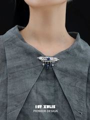 Blue stone tassel brooch pinned to clothing