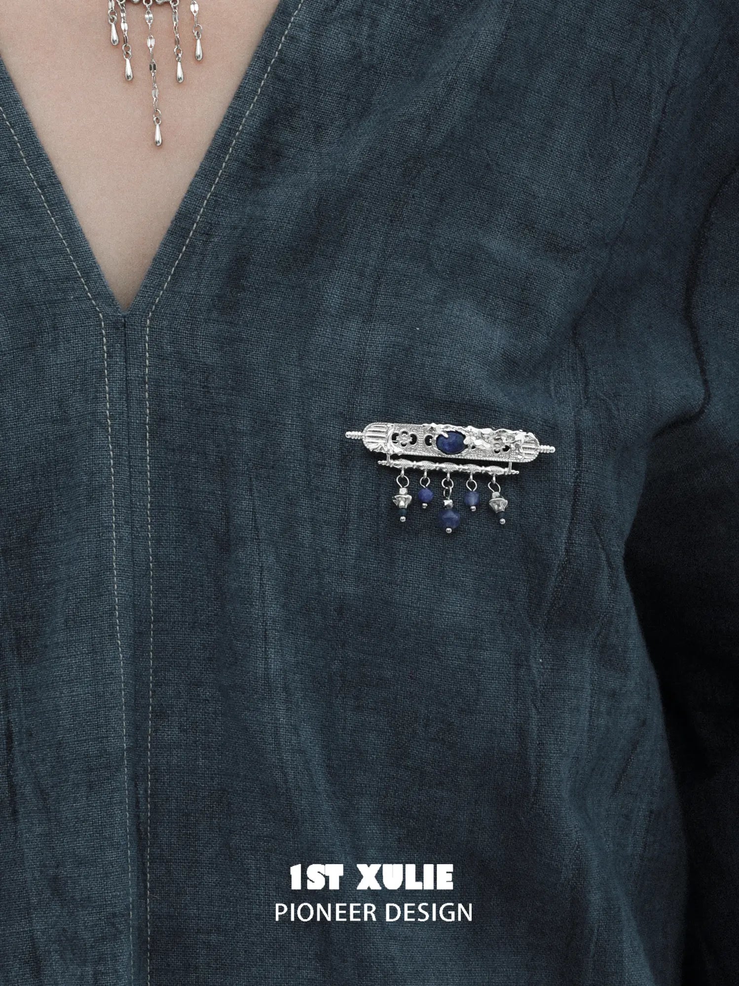 Blue stone tassel brooch pinned to clothing