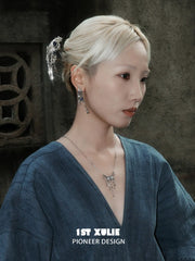 Blue stone tassel hoop earrings worn with the hair tucked back
