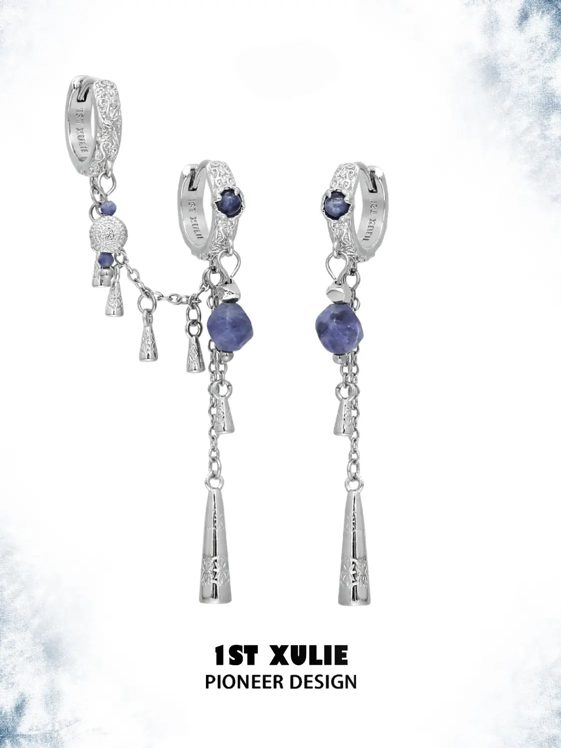 Asymmetrical hoop and tassel earring pair against a pale decorative background