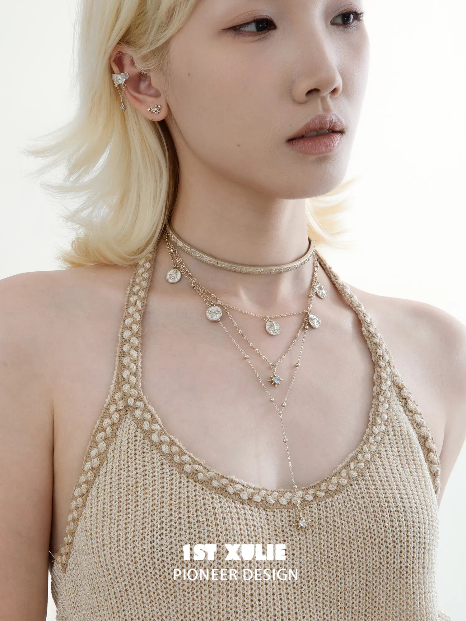 Side portrait showing the layered celestial necklaces