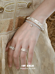 Celestial medallion and patterned band rings worn with coordinating jewelry