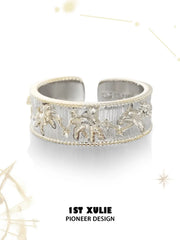 Patterned open band ring against a pale celestial background