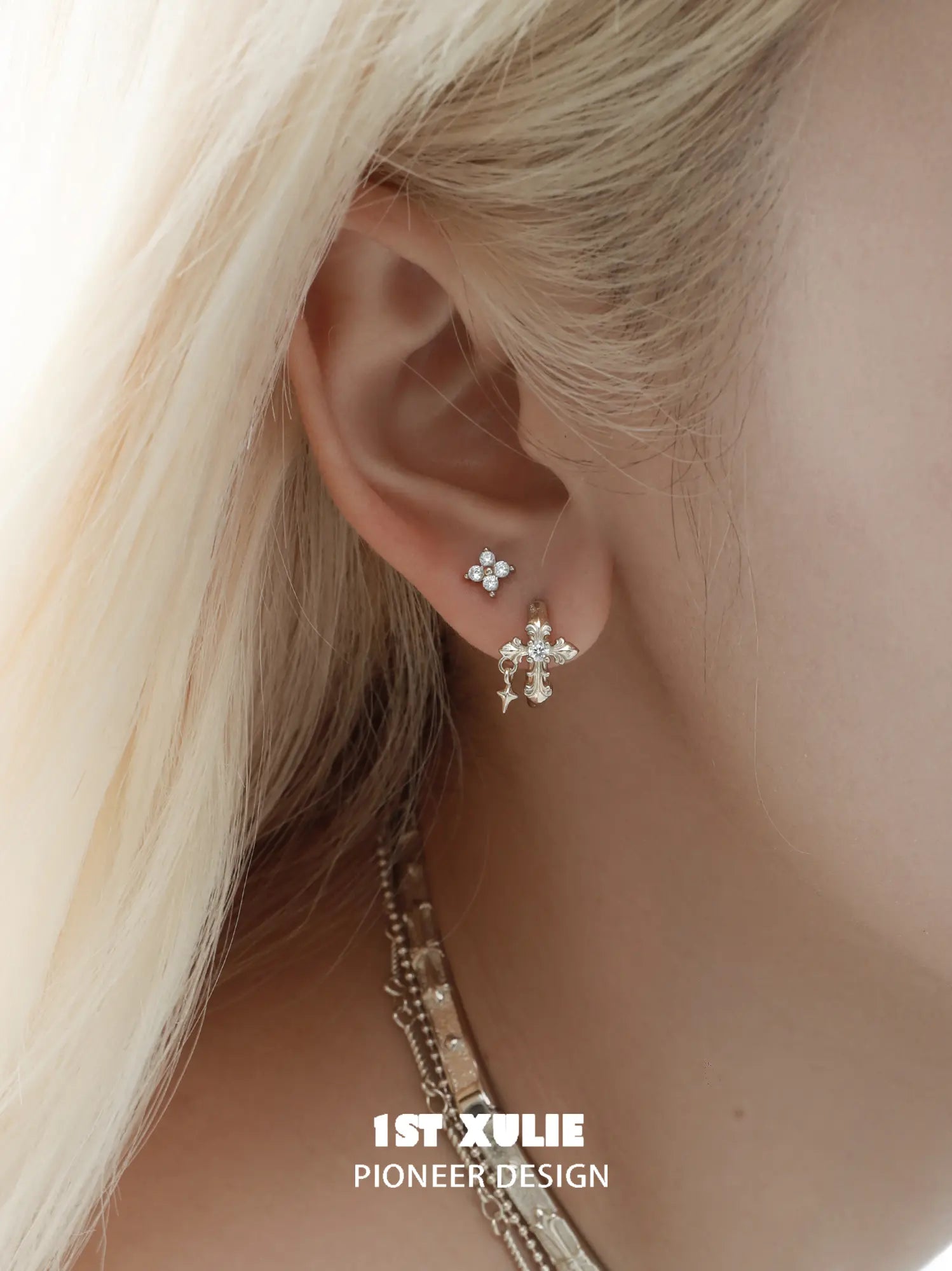 Gold-toned fleur-de-lis hoop and stud earrings worn on the ear