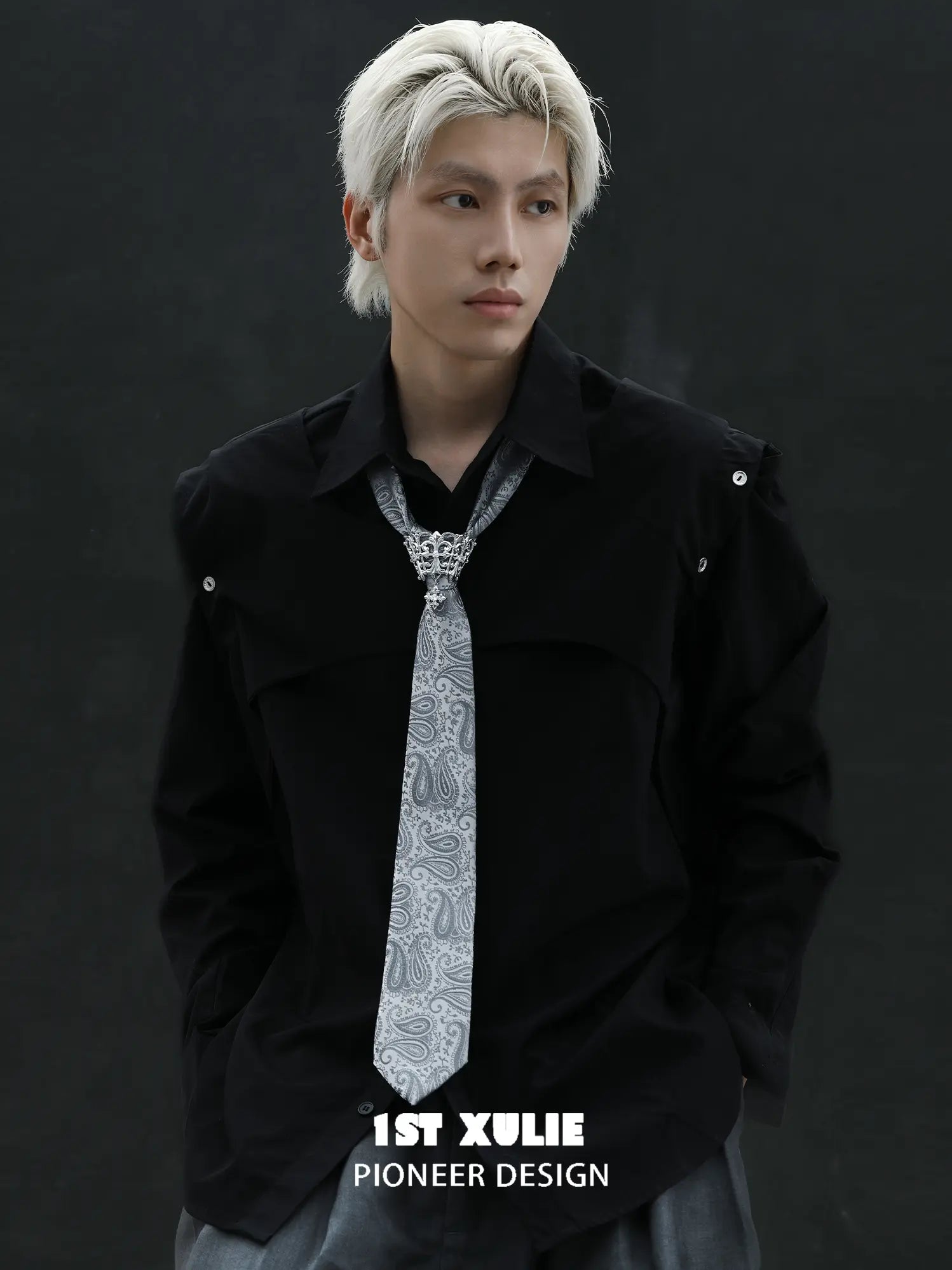 Silver-toned tie brooch styled with a patterned necktie and dark jacket