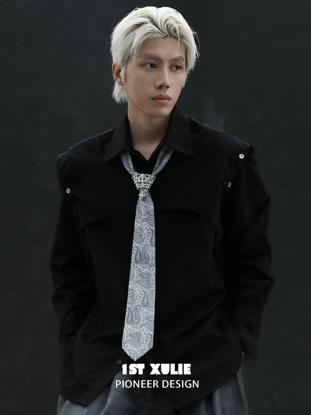 Silver-toned tie brooch styled with a patterned necktie and dark jacket