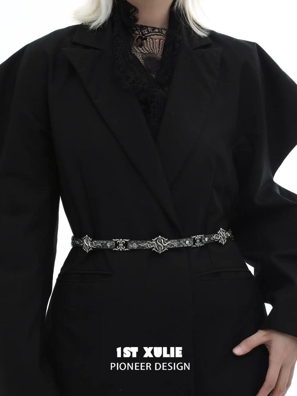 Fleur-de-lis chain belt worn over a dark blazer