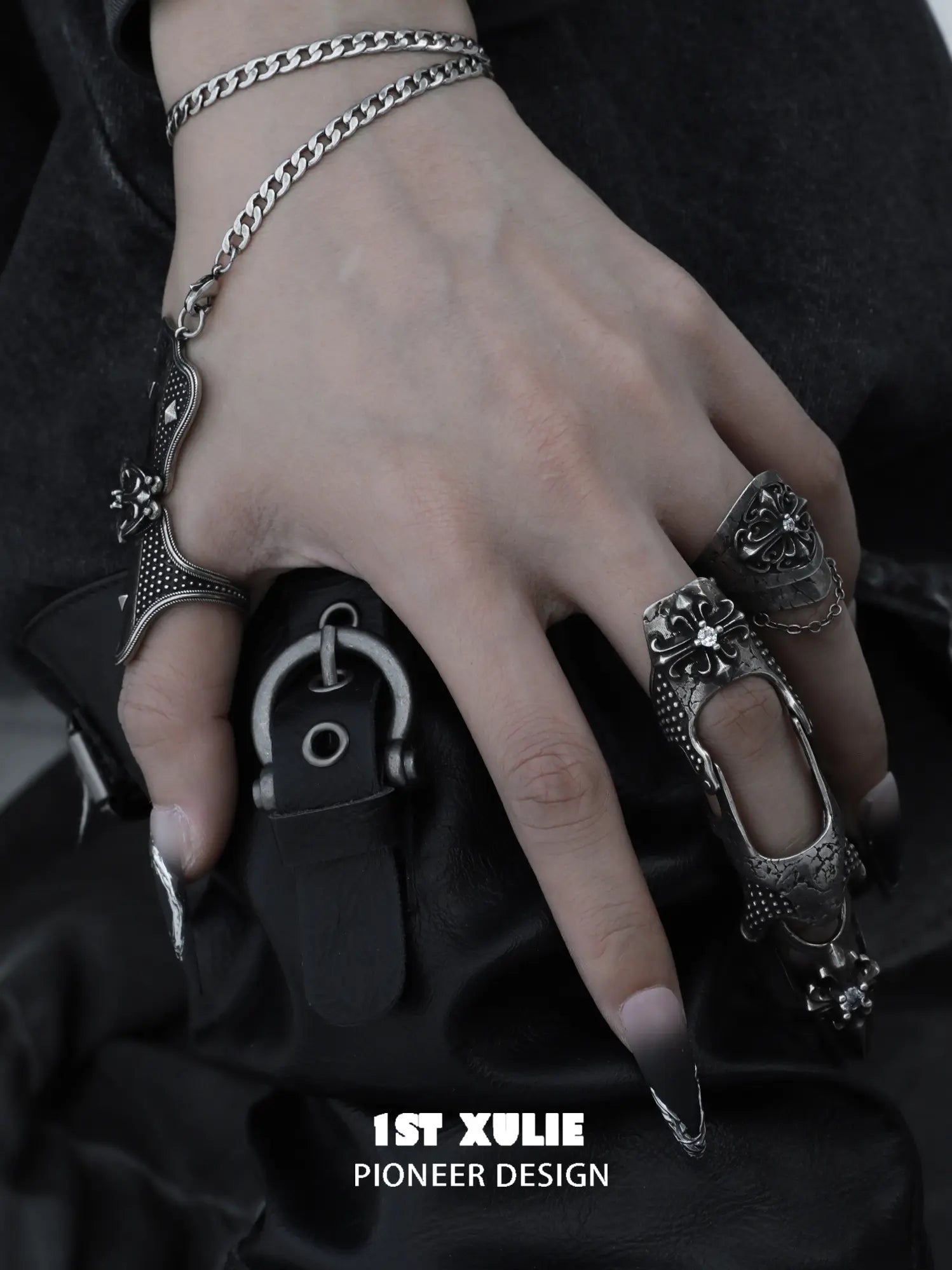 Gothic thumb armor ring and wrist chain worn with coordinating jewelry