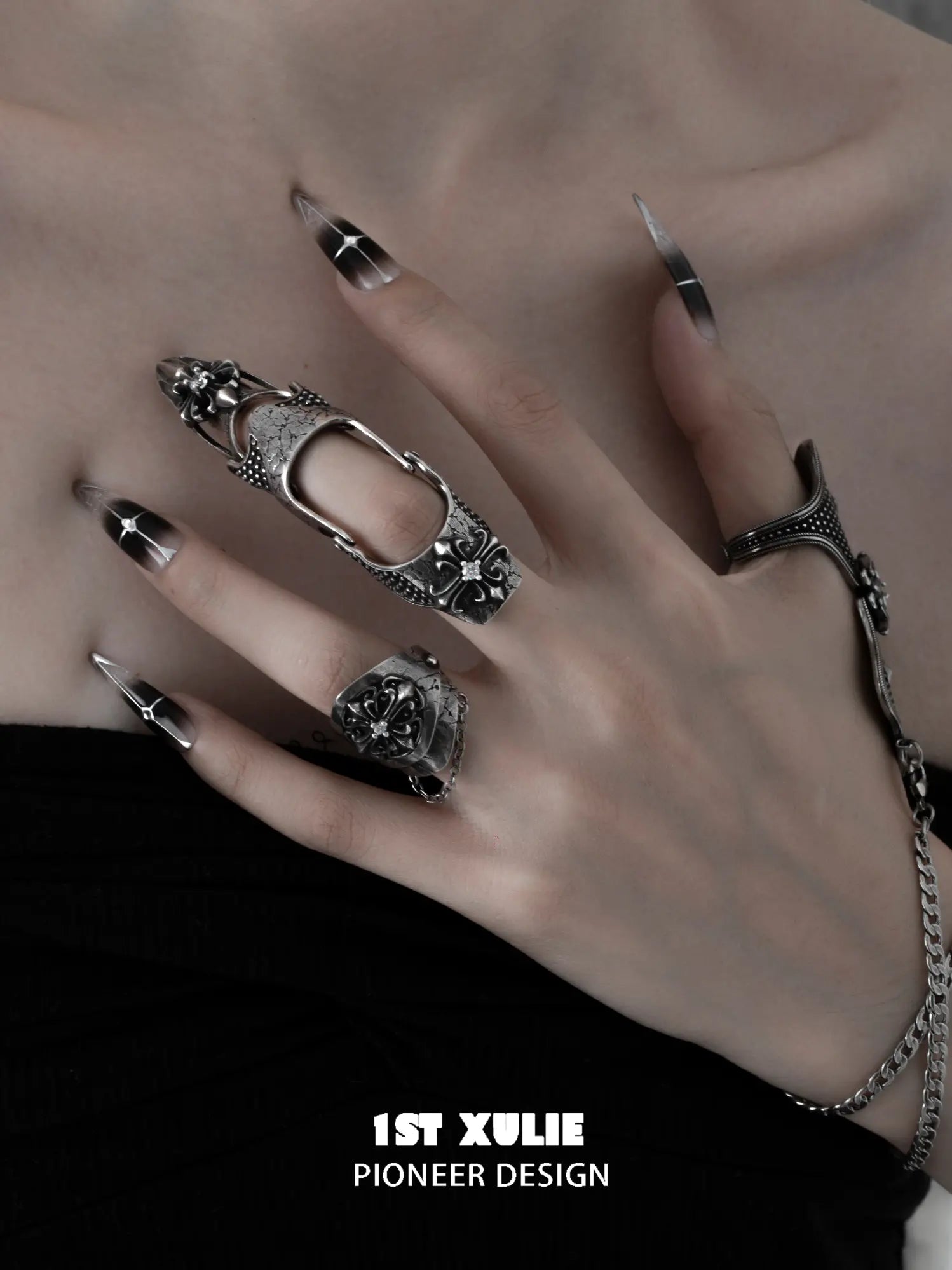 Gothic thumb armor ring and wrist chain worn with coordinating jewelry