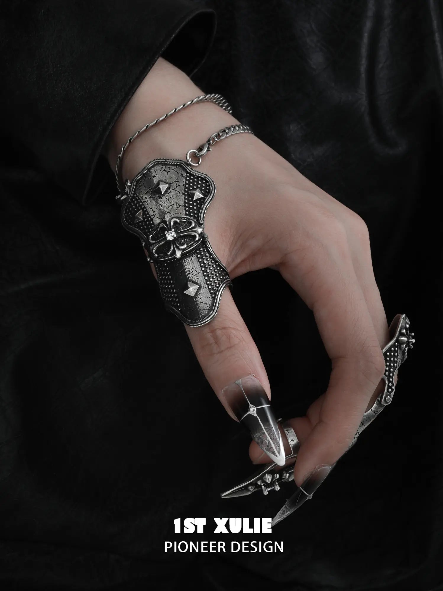Angled close-up of the darkened metal thumb armor