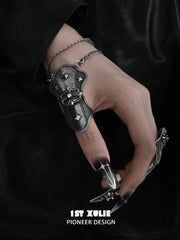 Angled close-up of the darkened metal thumb armor