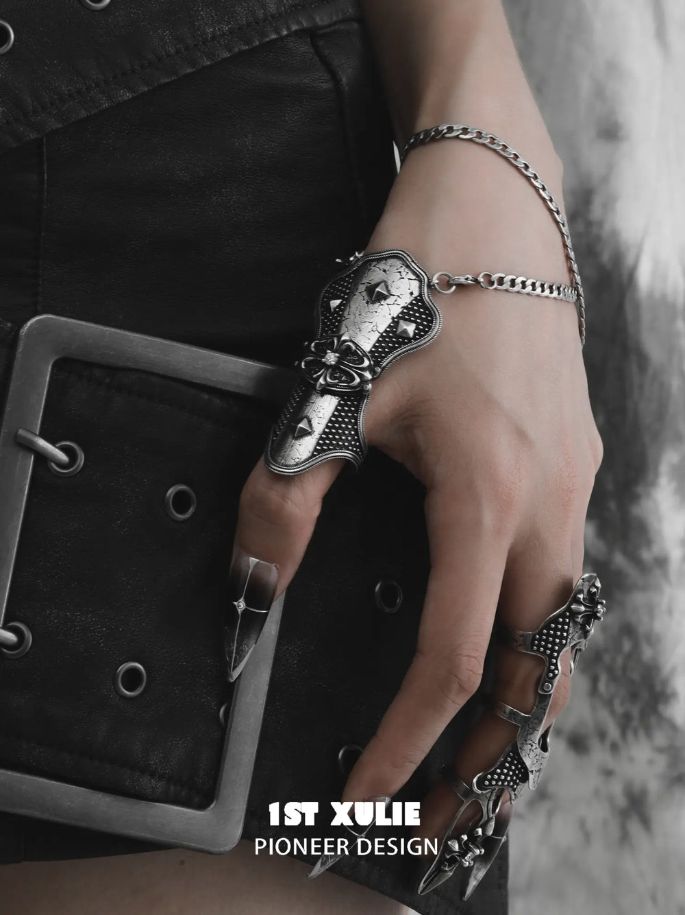 Gothic thumb armor ring and wrist chain worn with coordinating jewelry