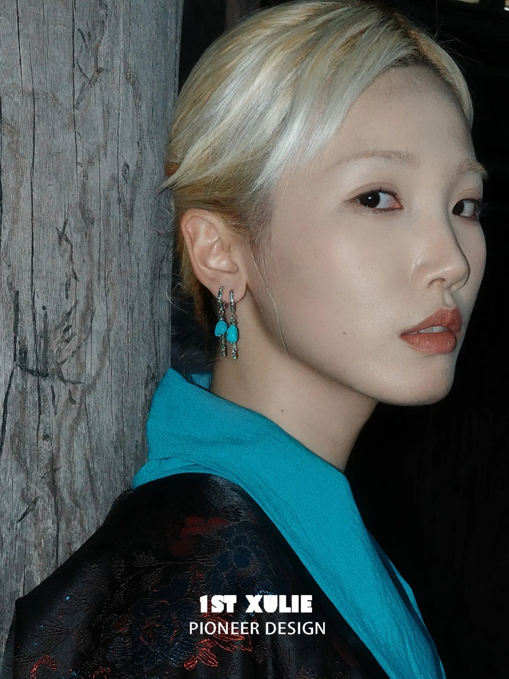 Natural turquoise drop hoop earrings worn on the ear