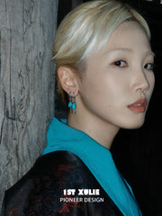 Natural turquoise drop hoop earrings worn on the ear