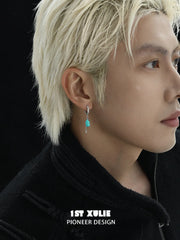 Model wearing a turquoise drop hoop earring in a side portrait